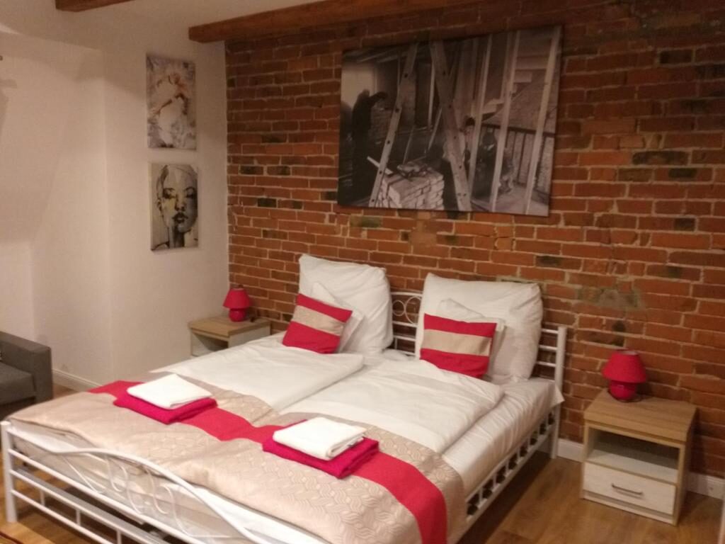 Sypialnia z ceglaną ścianą i drewnianymi belkami